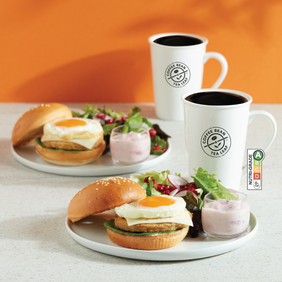 A delicious Chicken Patty & Sunny Side Up Breakfast Burger Set from The Coffee Bean & Tea Leaf, featuring a burger, mini yogurt, and side salad.