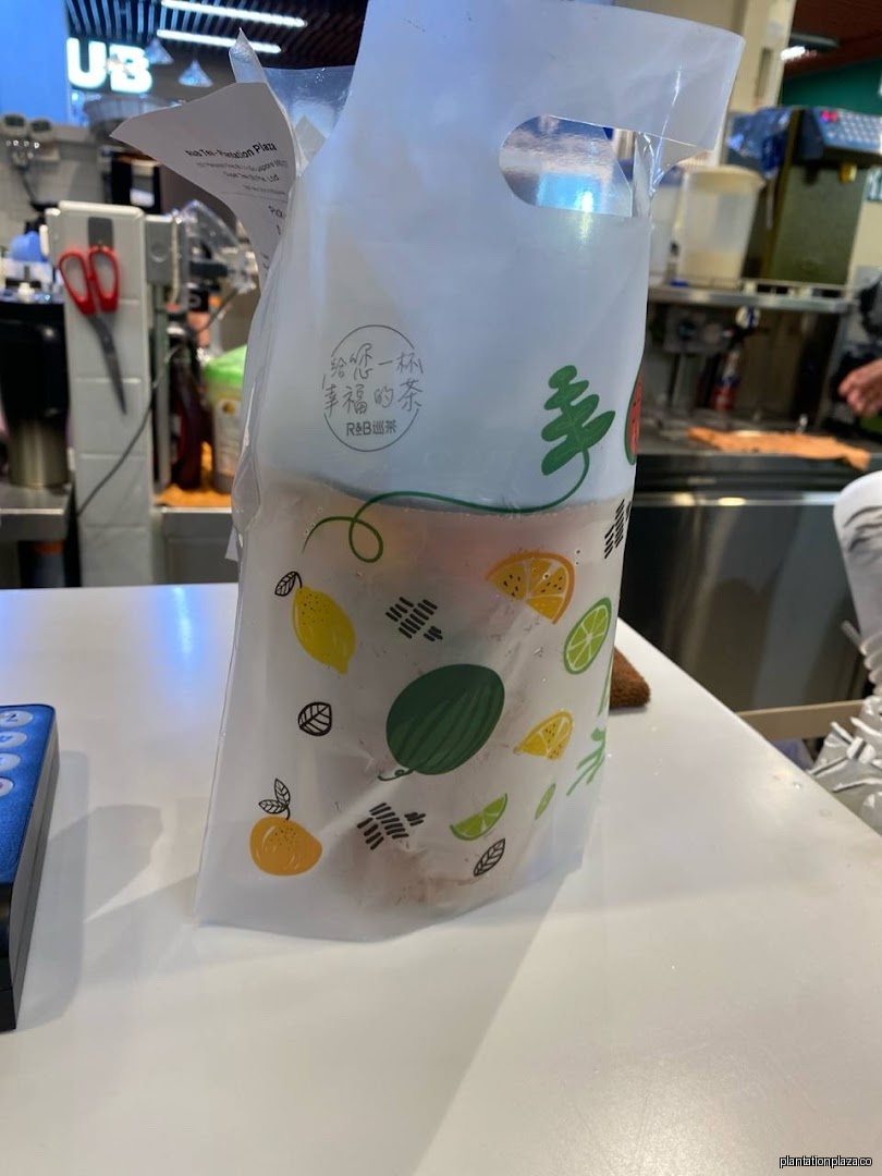 A clear plastic bag with fruit designs sits on a white counter inside a shop.