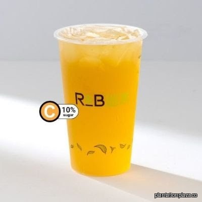 A clear plastic cup of yellow R&B Tea drink.